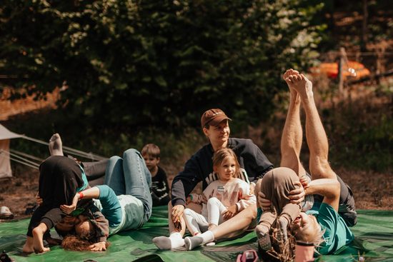 Парная растяжка на пледе, взрослые держат детей на вытянутых руках